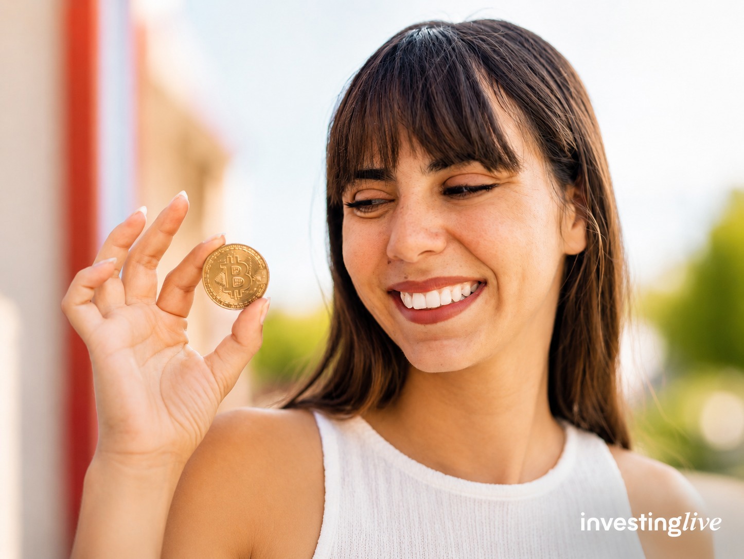 Woman holding bitcoin, investingLive.com
